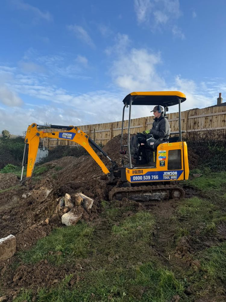 Mini digger clearing ground for a new extension
